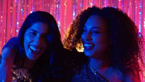 Portrait-Of-Two-Women-Friends-Having-Fun-Dancing-In-Nightclub-Bar-Or-Disco-With-Sparkling-Lights